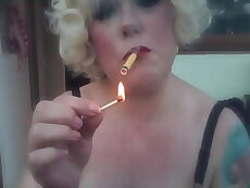 A Blonde Retro Mistress Smoking A Yellow Sobranie Cigarette With Match Light Up